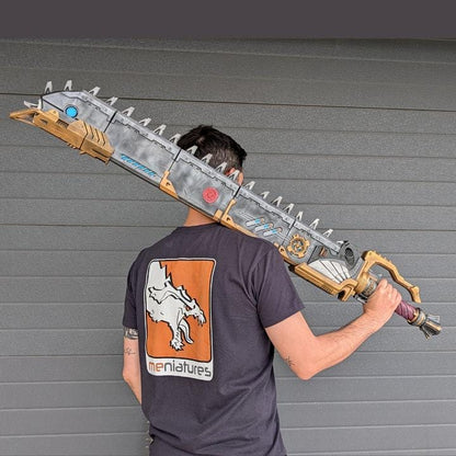 A person is holding a large, metallic sword-like weapon with a dragon design on it.