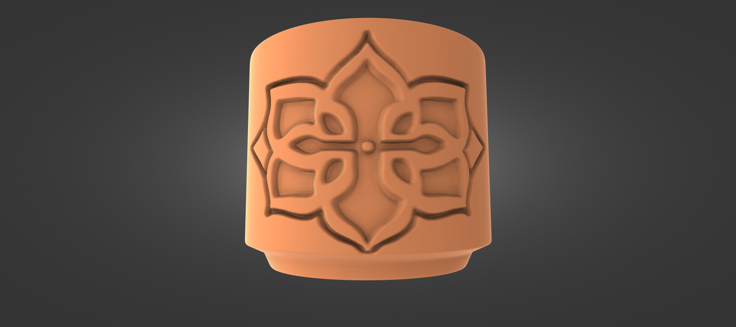 An orange ceramic object with an intricate floral design on it.