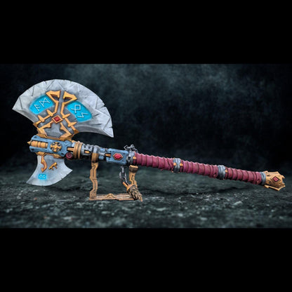 A detailed and ornate fantasy weapon, possibly a sword or axe, with intricate designs and patterns. The weapon appears to be a collectible item or a prop, displayed on a stand against a dark background.