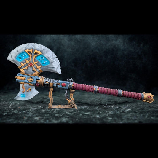 A detailed and ornate fantasy weapon, possibly a sword or axe, with intricate designs and patterns. The weapon appears to be a collectible item or a prop, displayed on a stand against a dark background.