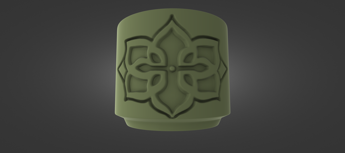 A green, cylindrical object with an intricate, symmetrical design on it, set against a dark background.