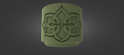 A green, cylindrical object with an intricate, symmetrical design on it, set against a dark background.
