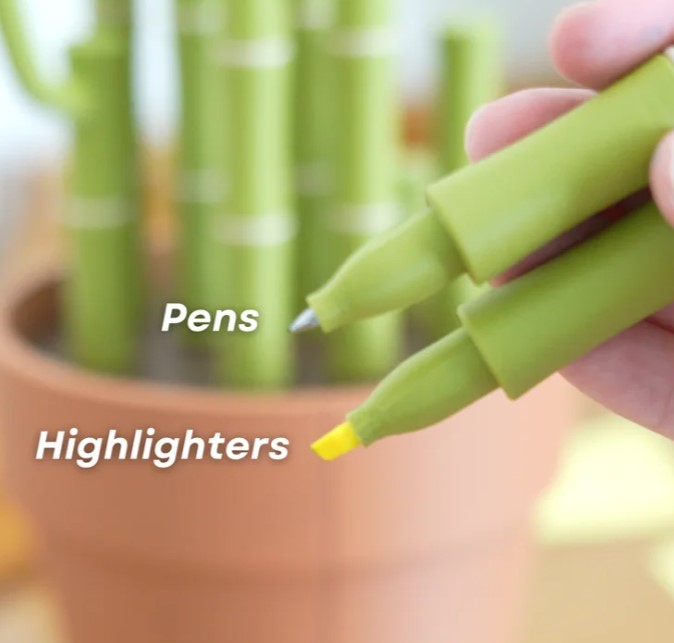 A hand holding a green highlighter pen and a green pen in a pot of pens, with the text "Pens" and "Highlights" written above and below the pens, respectively.