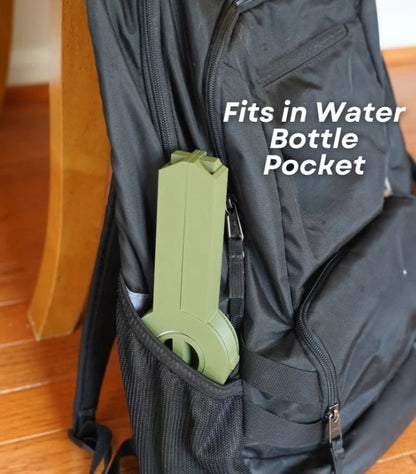 A black backpack with a green bottle pocket attached, and the text "Fits in Water Bottle Pocket" printed on the backpack.