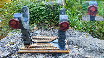 a pair of gray and red slingshots with skull-shaped handles, placed on a wooden base.