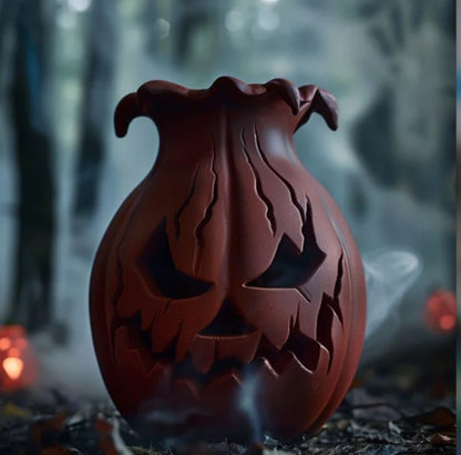 A carved pumpkin with a carved face sits on a bed of leaves, with a misty, dark background.