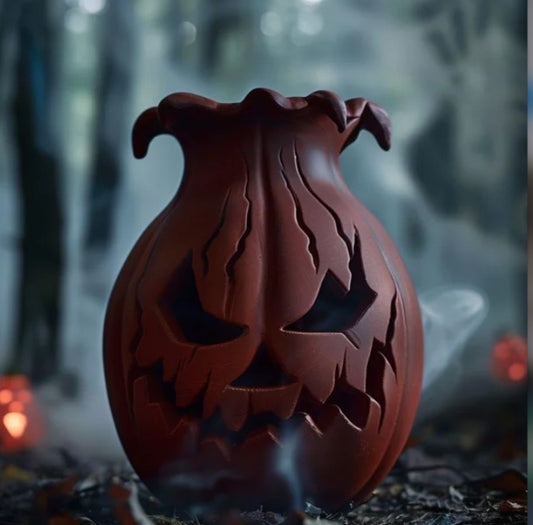 A carved pumpkin with a carved face sits on a bed of leaves, with a misty, dark background.