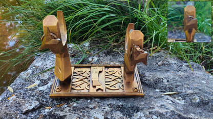 a pair of wooden objects, possibly a pair of scissors or a similar cutting tool, placed on a rock. The objects appear to be carved and have a distinct design.
