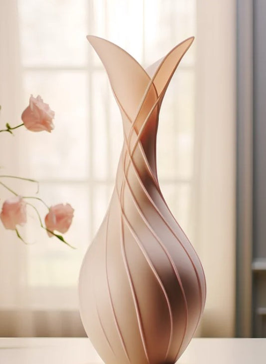 A tall, slender vase with a unique, swirling design sits on a table, with a few pink roses visible in the background.