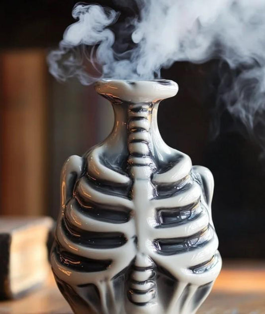 A ceramic vase with a black and white design resembling a skeleton, emitting smoke from its opening.